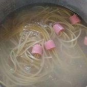 步驟圖:火腿腸切小段，一小段火腿腸插入六根通心粉。鍋中燒水
