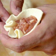 步驟圖:將生煎皮用搟面杖搟成圓形，包入肉餡，收口朝下。